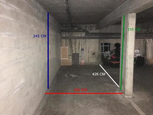 En sous-sol de co-proprit.  Un mur en parpaing et une porte de garage - 1
